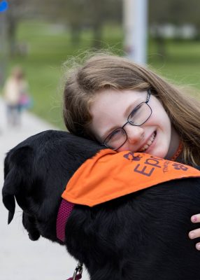Girl smiling and petting therapy dog.
