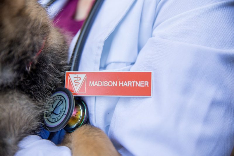 Close up of a white coat and name tag.